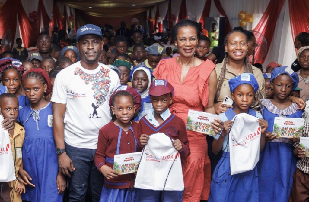 L–R: Senior Programmes Manager, Slum2School Africa, Adekunle Idowu; Managing Director, UBA Foundation, Bola Atta; and Segment Executive, Children and Youth Banking, UBA, Ozioma Obi, with pupils at the financial literacy workshop convened by UBA Foundation and Slum2School Africa, where the children received the UBA Money Explorers Book, in Lagos, recently