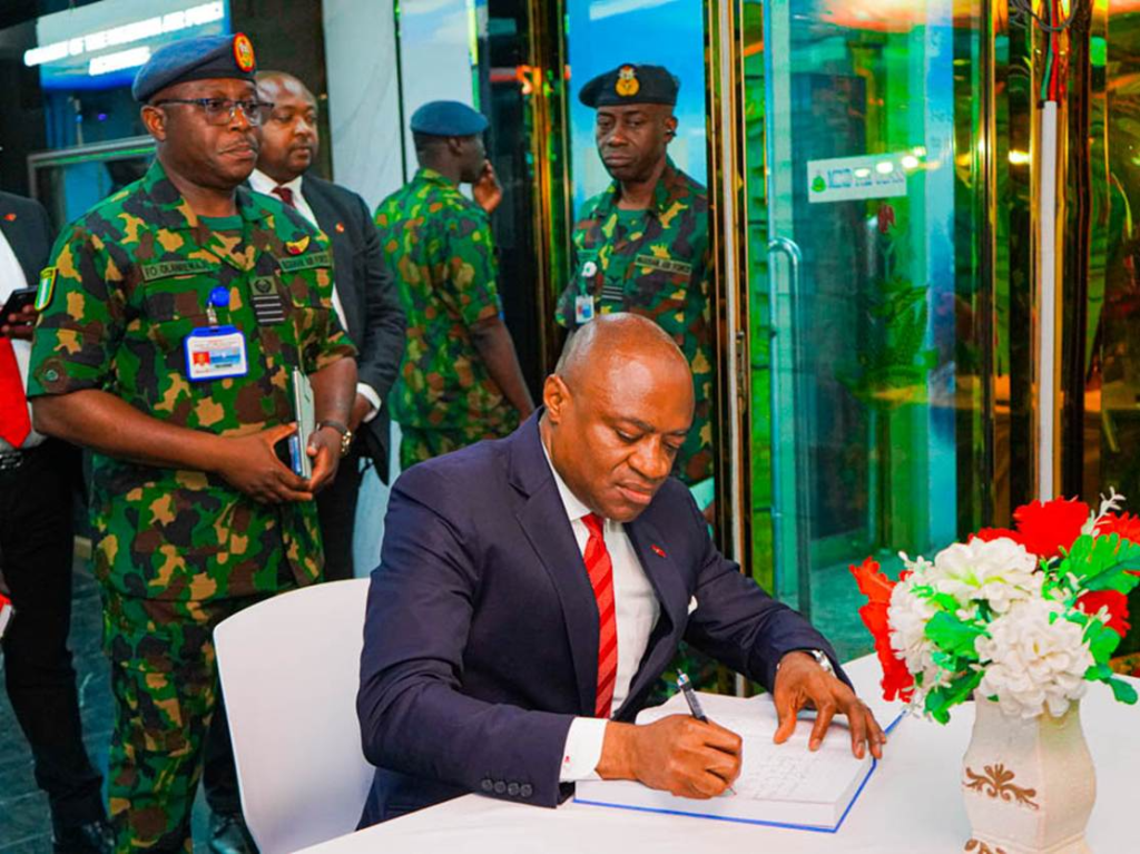 L-r:  Group Managing Director/CEO, United Bank for Africa (UBA) Plc, Oliver Alawuba, signing the condolence register during the GMD’s visit to the NAF Headquarters, Abuja, to commiserate with the Air Force over the NAF 931 crash, standing at his back is the  Principal Staff Officer of the Mission, Nigerian Air Force (NAF), Group Captain F. O. Olanrewaju, in Lagos on Monday.