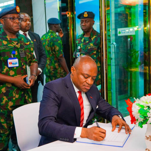 L-r: Group Managing Director/CEO, United Bank for Africa (UBA) Plc, Oliver Alawuba, signing the condolence register during the GMD’s visit to the NAF Headquarters, Abuja, to commiserate with the Air Force over the NAF 931 crash, standing at his back is the Principal Staff Officer of the Mission, Nigerian Air Force (NAF), Group Captain F. O. Olanrewaju, in Lagos on Monday.